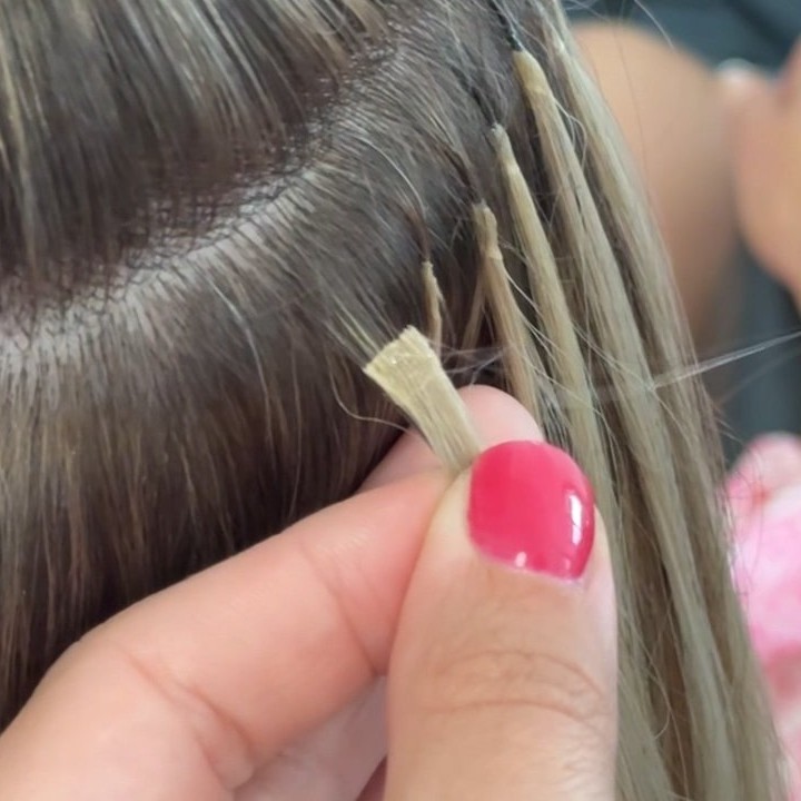 Close-up of keratin bond hair extension being attached by Alina Kalinichenko