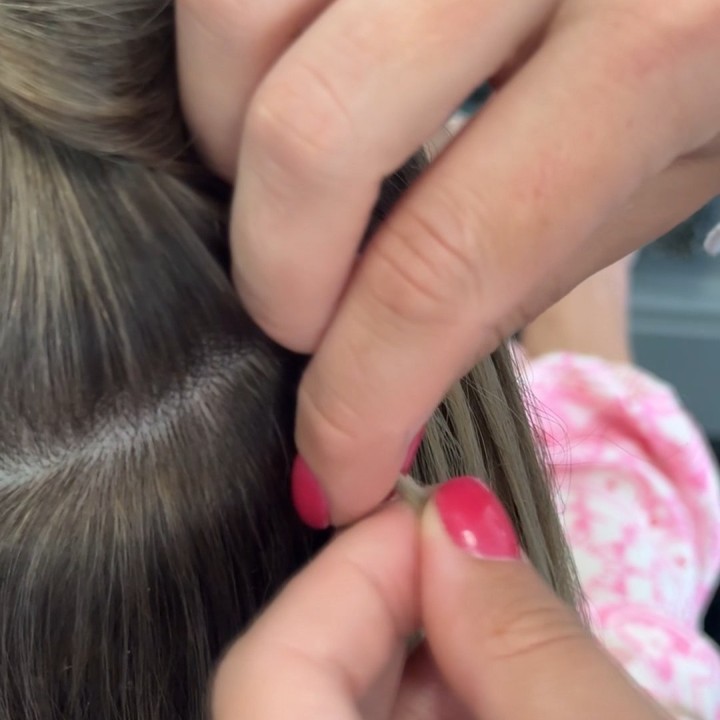 Alina Kalinichenko sealing a keratin extension bond during the application process