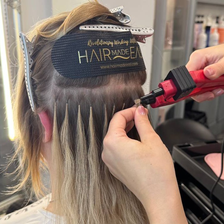 Securing individual hair extensions with a heat tool during application